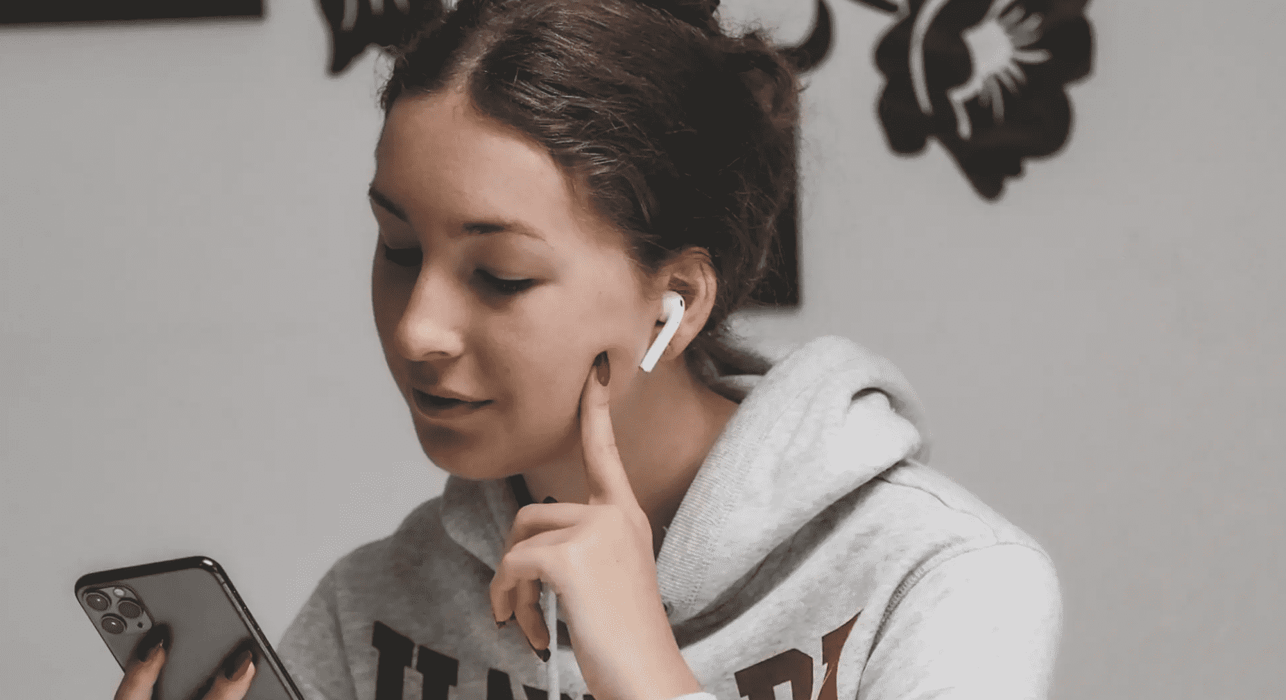 Chica con audífonos revisando su teléfono