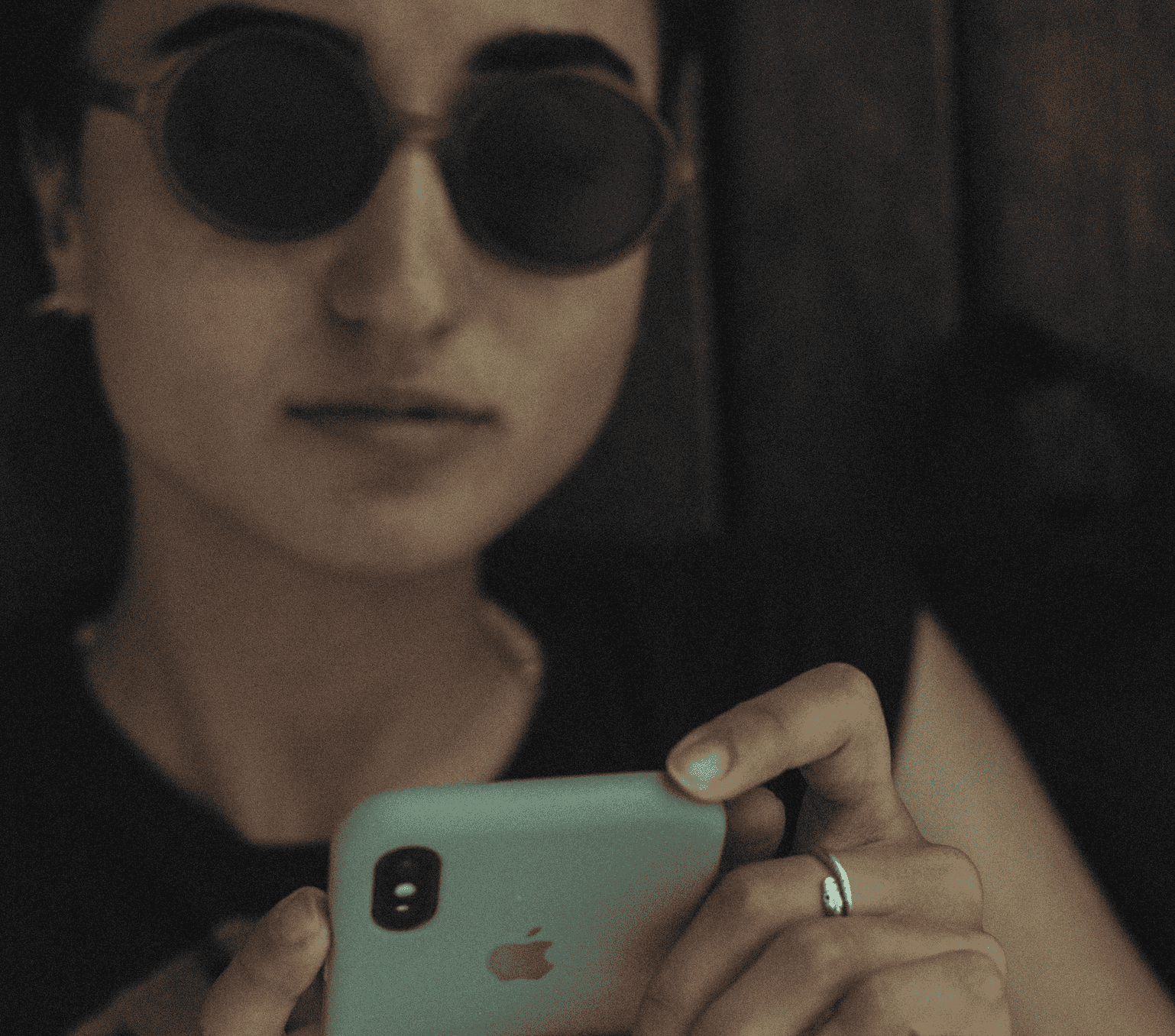Chica con gafas negras revisando su teléfono