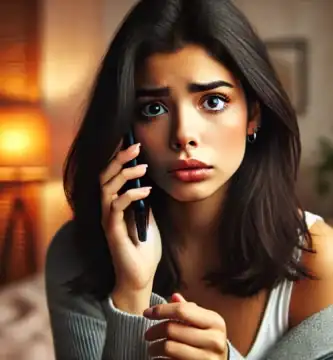 DALL·E 2024 06 23 12.50.31 A beautiful Latina young woman with olive skin and black hair looking anxious as she receives a call. She is holding her smartphone and looking at it