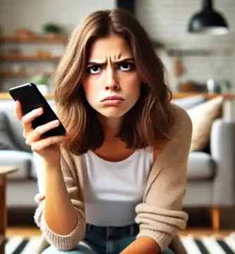 DALL·E 2024 06 23 12.29.04 A young woman looking annoyed as she receives a spam call. She is holding a smartphone with an exasperated expression her eyebrows furrowed and mouth