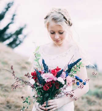 girl holding assorted bouquet flowers while looking down