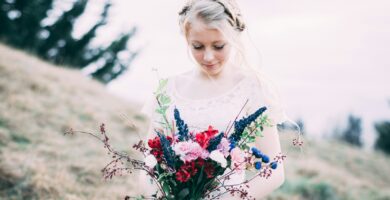 girl holding assorted bouquet flowers while looking down