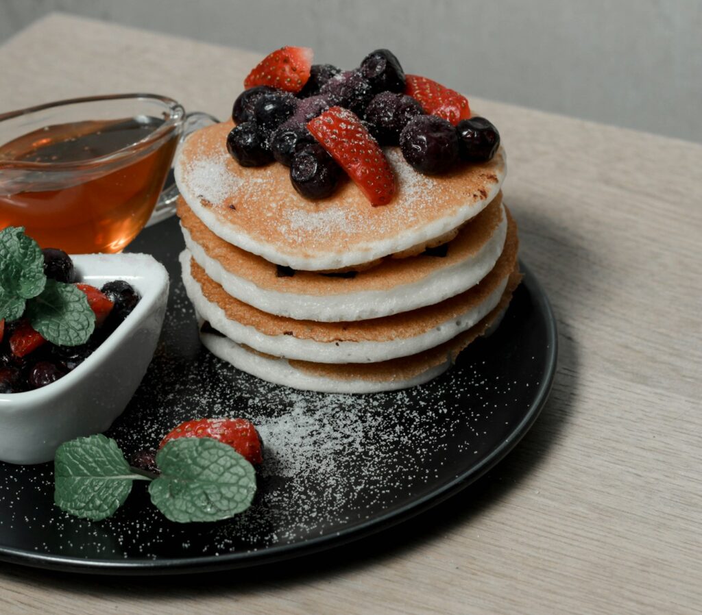 como hacer tortitas pancakes with berries and berries on black ceramic plate