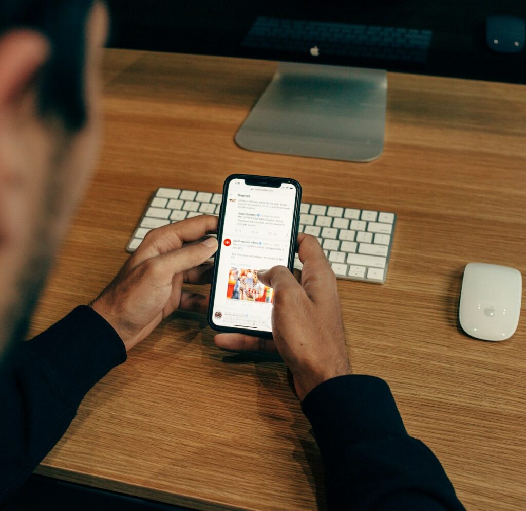 Breaking News or Fake News man holding phone while leaning on table