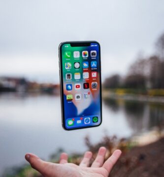 reiniciar un iPhone silver iPhone X floating over open palm