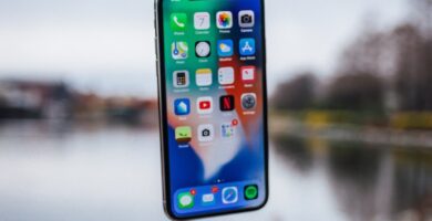 reiniciar un iPhone silver iPhone X floating over open palm