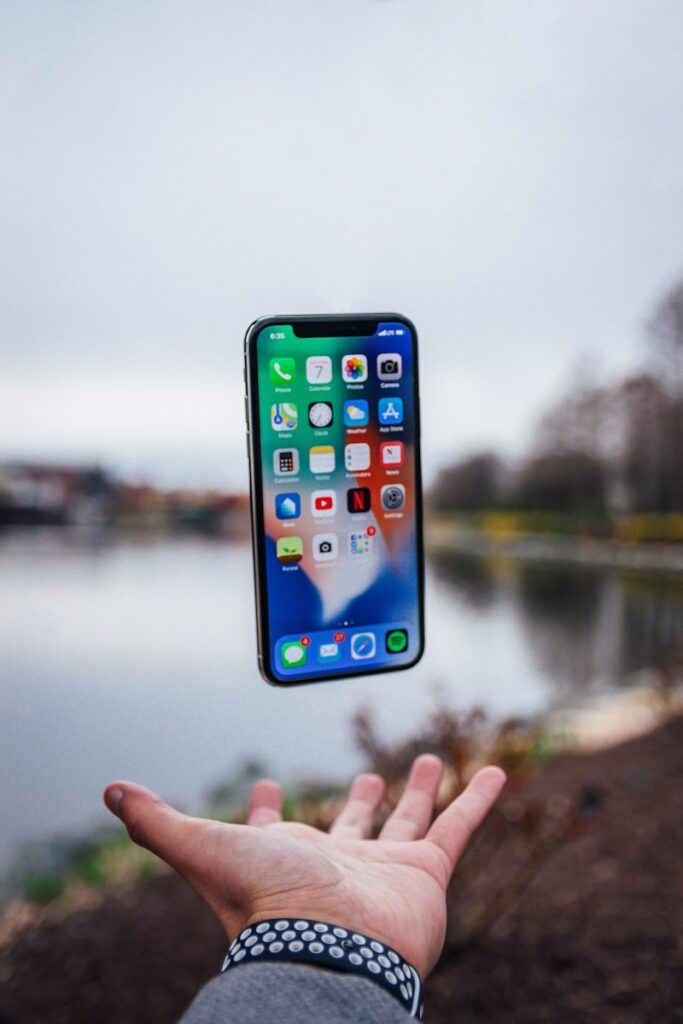 reiniciar un iPhone silver iPhone X floating over open palm
