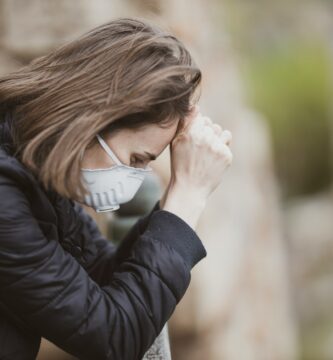 How to Get Rid of a Sore Throat woman in black leather jacket wearing white framed eyeglasses covering her face