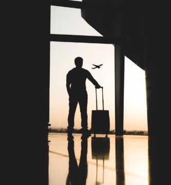 Smart Travel Tips silhouette of man holding luggage inside airport
