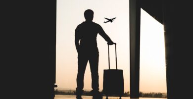 Smart Travel Tips silhouette of man holding luggage inside airport