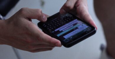 WhatsApp person holding black iphone 4