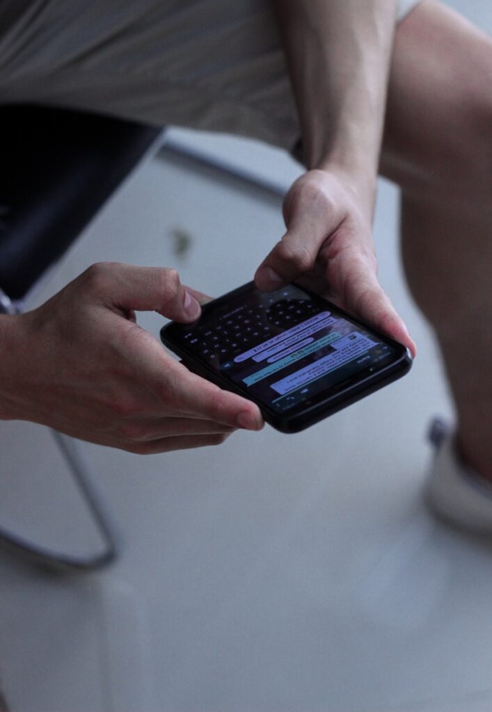 WhatsApp person holding black iphone 4