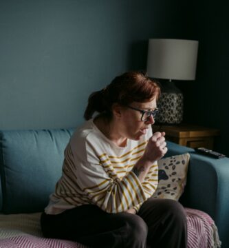 quitar hipo woman in white crew neck t-shirt sitting on gray sofa